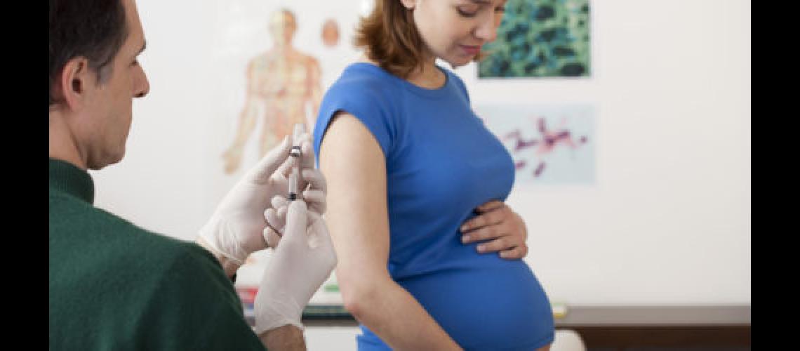 Pregnant woman about to get shot from doctor in office