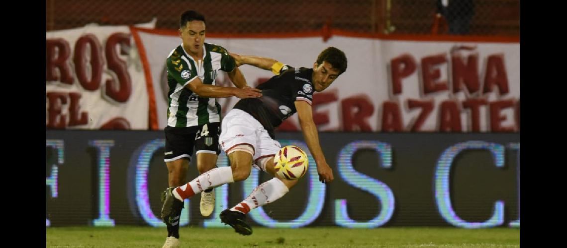 Carlos Araujo de muy buen desempentildeo cubre la pelota frente al intento de Luciano Goacutemez
