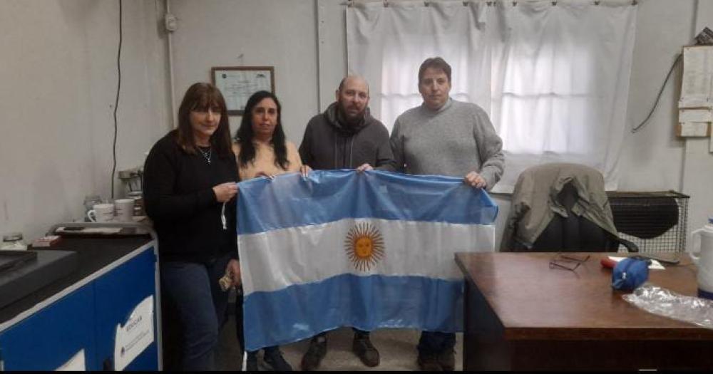 José junto a los directivos de la escuela La bandera lista para flamear