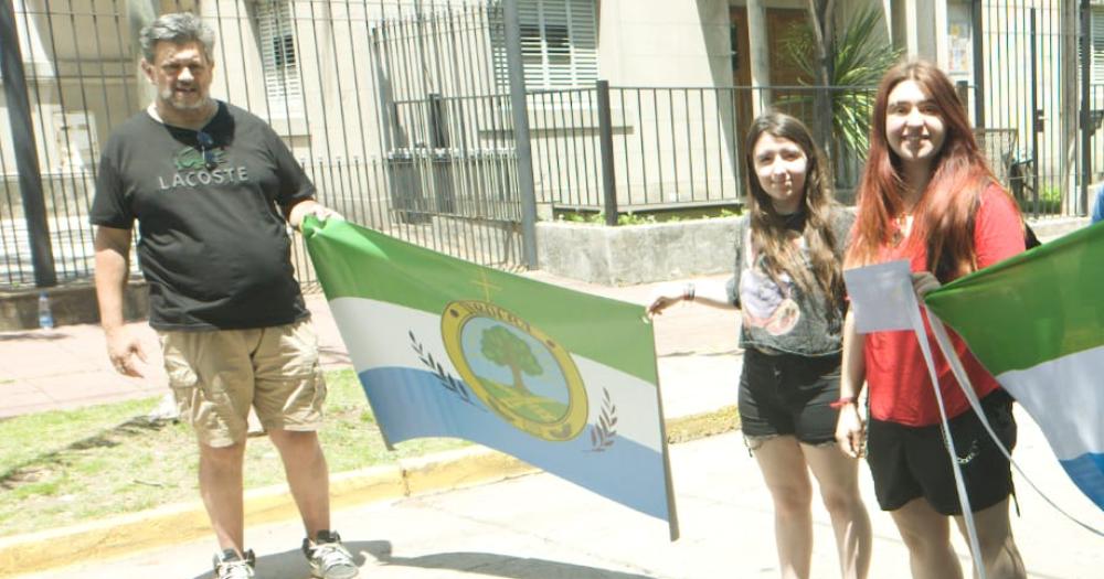 Sasha (con remera roja) junto a la bandera vecinal que creó